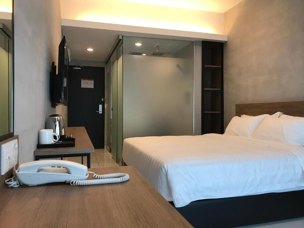 新邦波赖Dandelion Inn的酒店客房,配有一张床和一张书桌上的电话