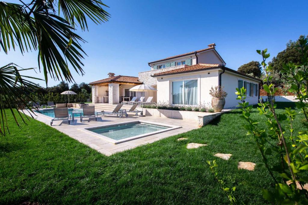 卡夫兰Mirana Luxury Villas的庭院中带游泳池的房子