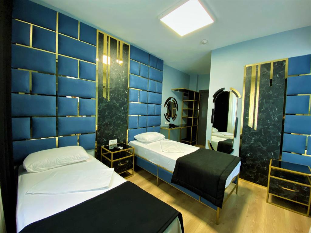 伊斯坦布尔桔子机场酒店的一间卧室设有两张床和蓝色的墙壁