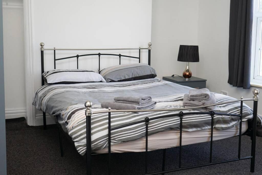 赫尔Hullidays - University Side Lg 4 bed House的一间卧室配有一张带金属框架的大床
