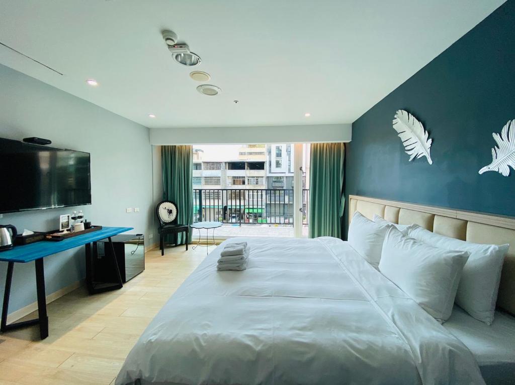 台中市台中丰禾行旅的一间卧室设有一张蓝色墙壁的大床