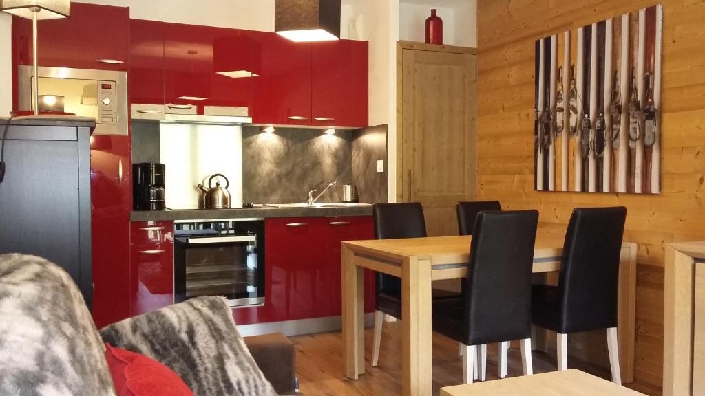 格尔姆T2 cabine vue montagne Valnéa Peyragudes的厨房配有红色橱柜和木桌