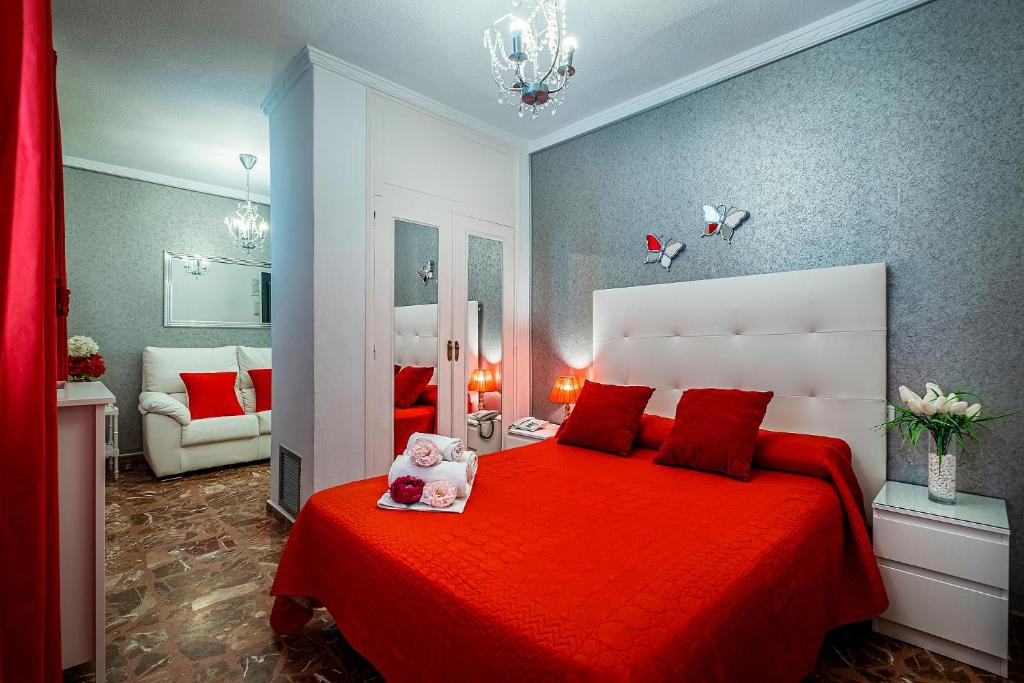 Ginés吉恩斯酒店的一间卧室配有一张红色大床和红色毯子