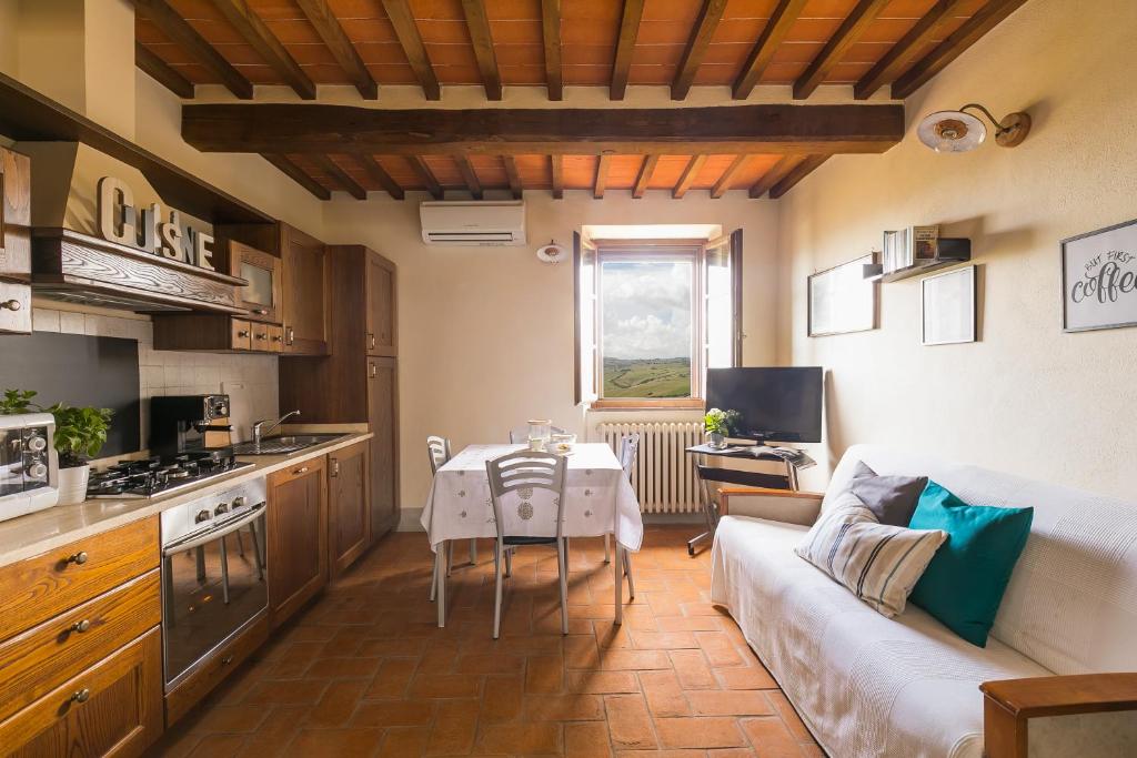Contignano卡萨弗郎公寓的厨房以及带沙发和桌子的客厅。