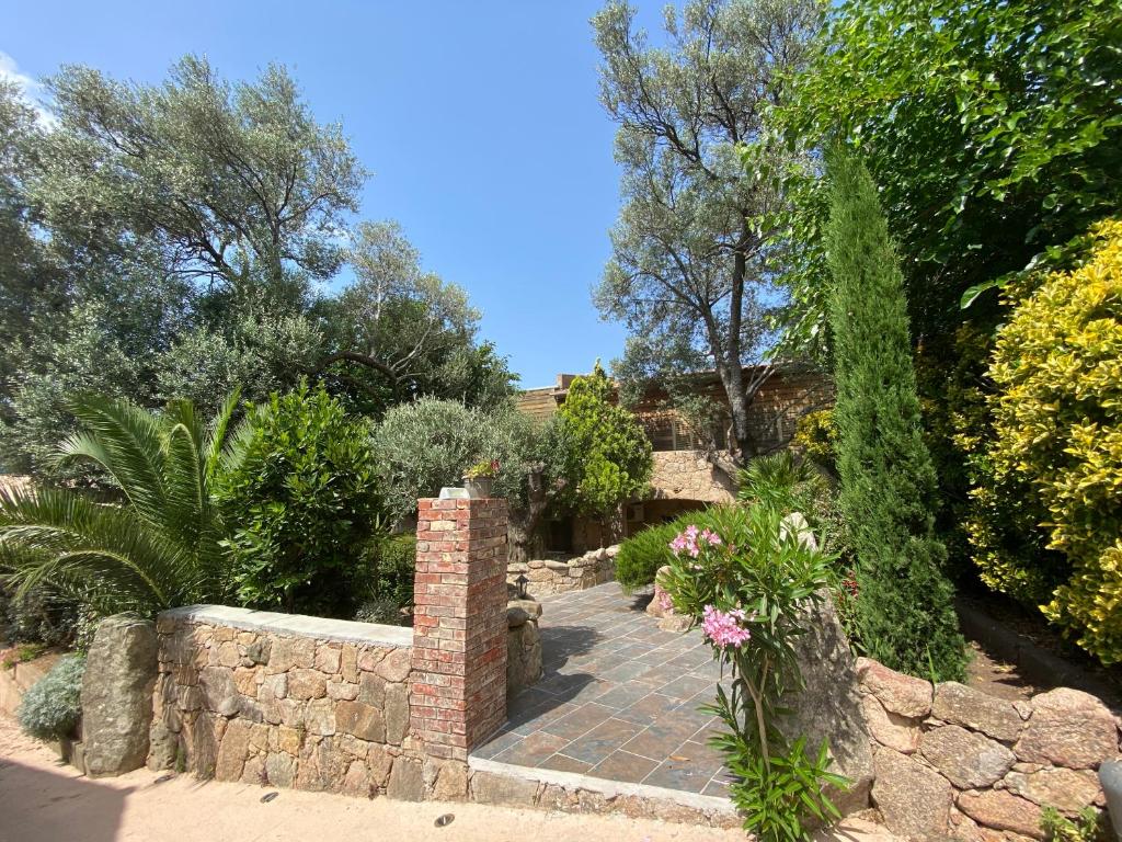 孔卡Hotel gite d'etape San Pasquale的一个带砖砌走道和石墙的花园