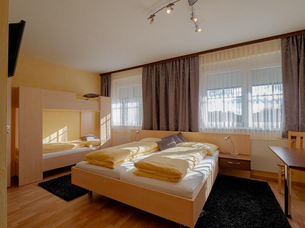 RattersdorfGasthof Familie Hutter的一间卧室设有两张床、一张桌子和窗户。