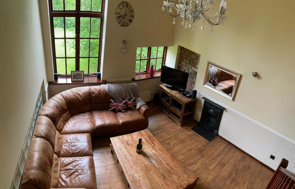 特尔福德Jackfield Mill Ironbridge Gorge的客厅配有真皮沙发和茶几