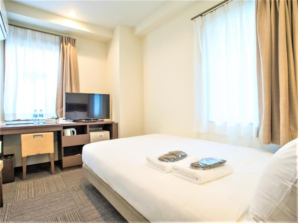 横滨SHIN YOKOHAMA SK HOTEL - Non Smoking - Vacation STAY 86107的酒店客房配有一张床、一张书桌和一台电视。