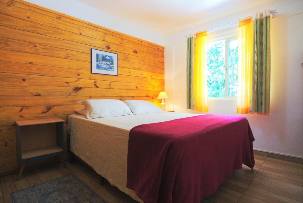 特雷齐蒂利亚斯Hospedaria Brigite - Apartamento de Férias的一间卧室配有一张木墙床