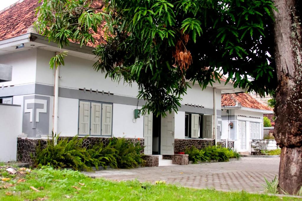 日惹纳尔姆曼特里加温酒店的前面有一棵树的白色房子