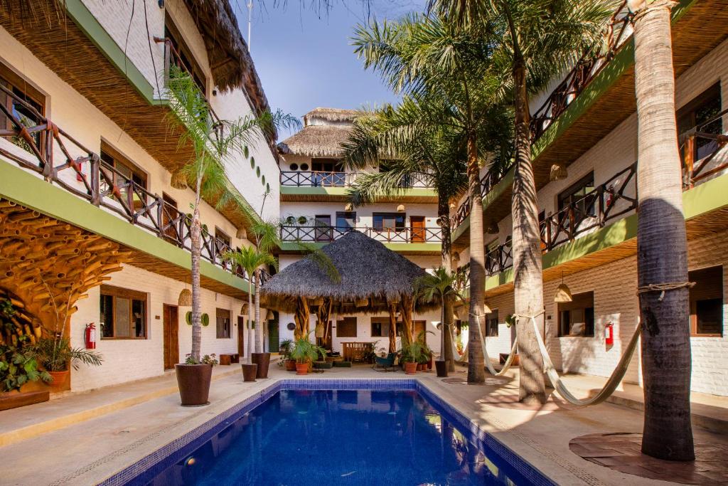 萨尤利塔Selina Sayulita的棕榈树建筑中带游泳池的庭院