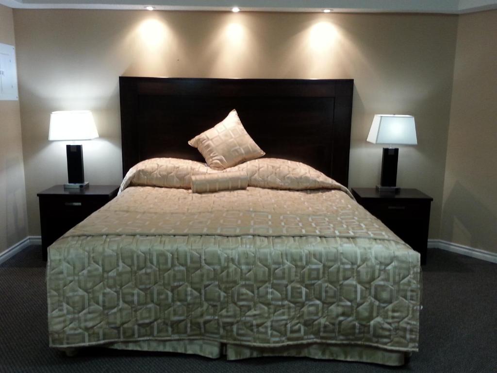 里贾纳日升汽车旅馆的一间卧室配有一张大床和两盏灯