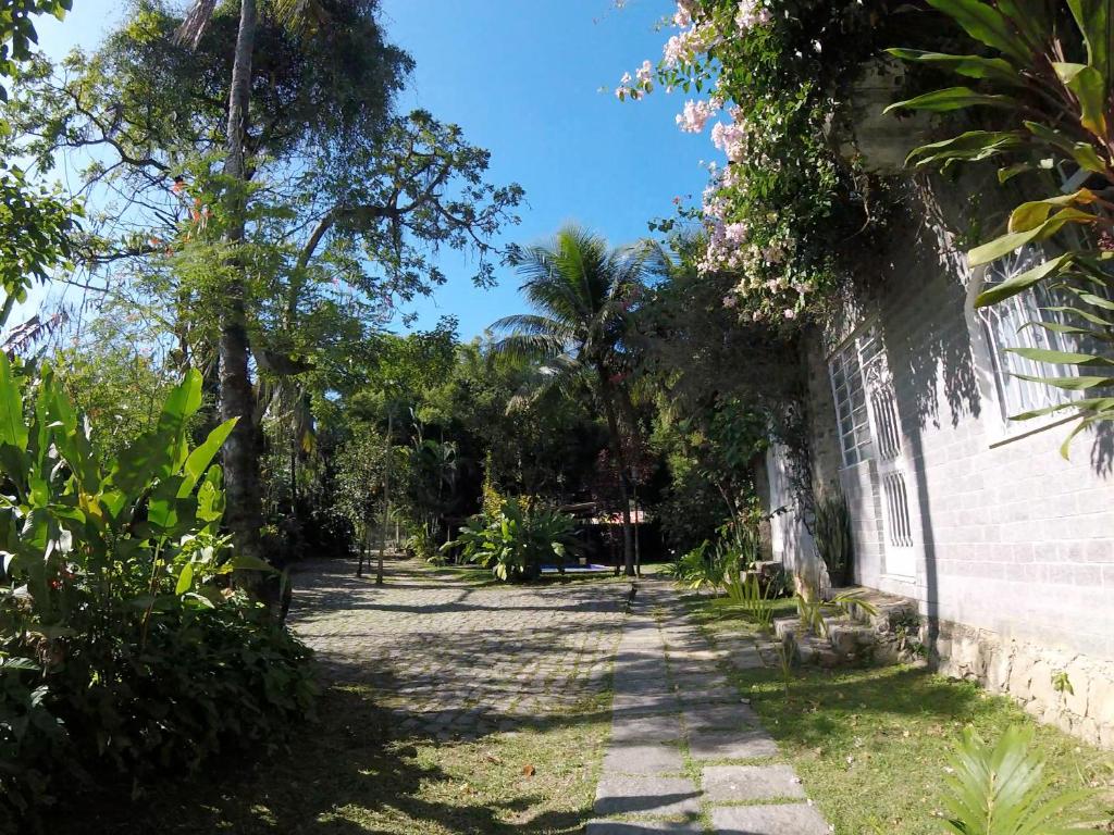 里约热内卢Rio Natureza apart 112的一座种有棕榈树的花园及一座建筑