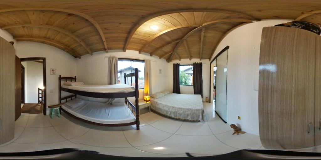 加罗帕巴Pousada Bem te vi的一间设有一张床铺的卧室,位于一个拥有木制天花板的房间