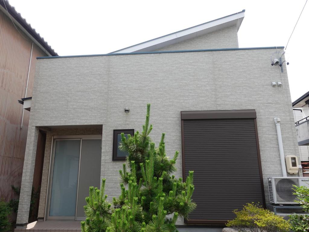 桑名市machiyado Kuwanajuku Honmachi 10的灰色的砖屋,有黑色的车库