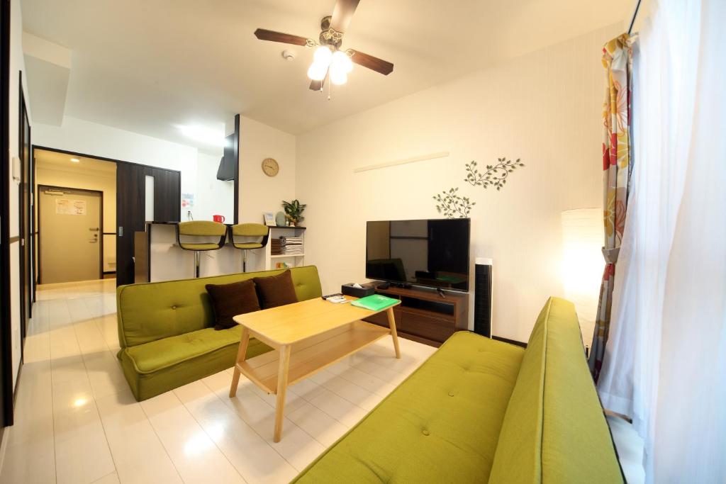 糸满EX Itoman Apartment 803的客厅配有绿色沙发和桌子