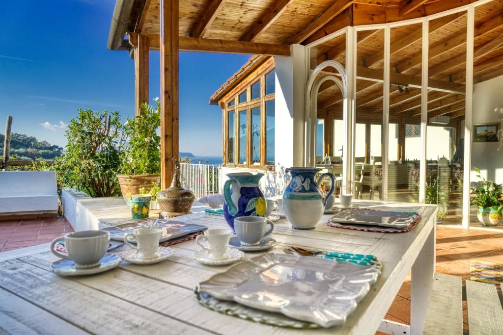 马萨鲁布朗斯Villa Lorelei的天井上带盘子和杯子的木桌