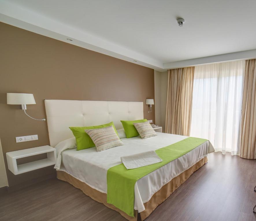 拉克鲁斯圣波隆顿RF酒店的一间卧室配有一张带绿色枕头的大床