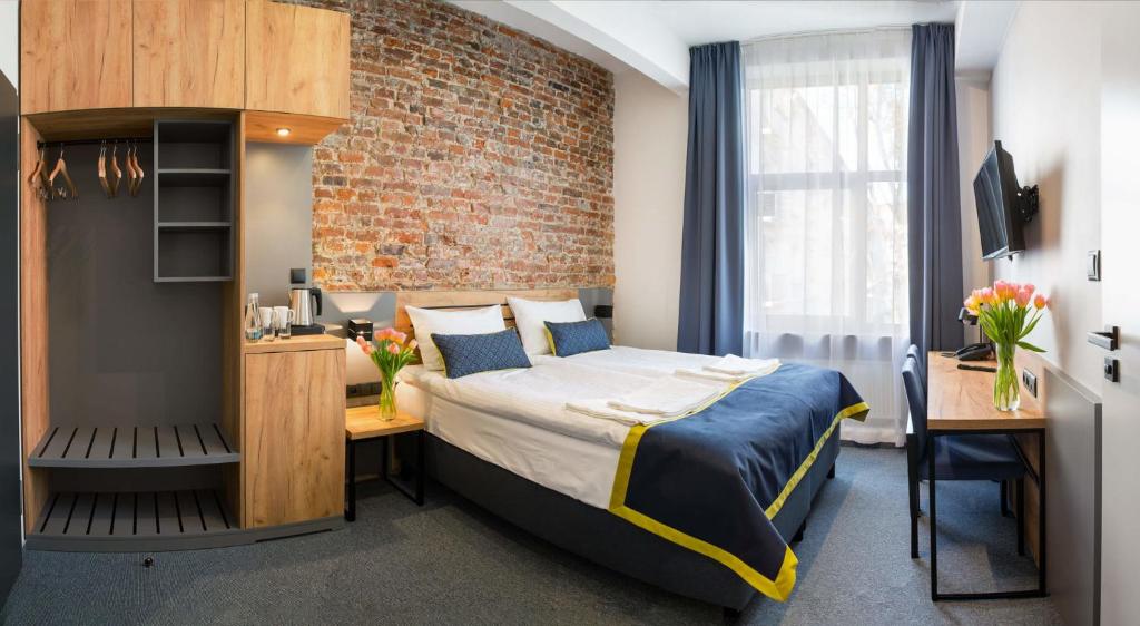 华沙Hotel Mokotów的一间卧室设有一张床和砖墙