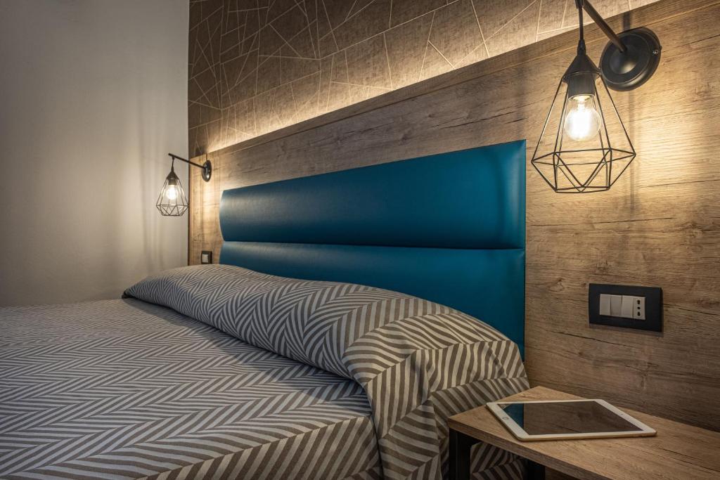 库尼奥库内奥酒店的一间卧室配有一张带蓝色床头板的床和一张桌子