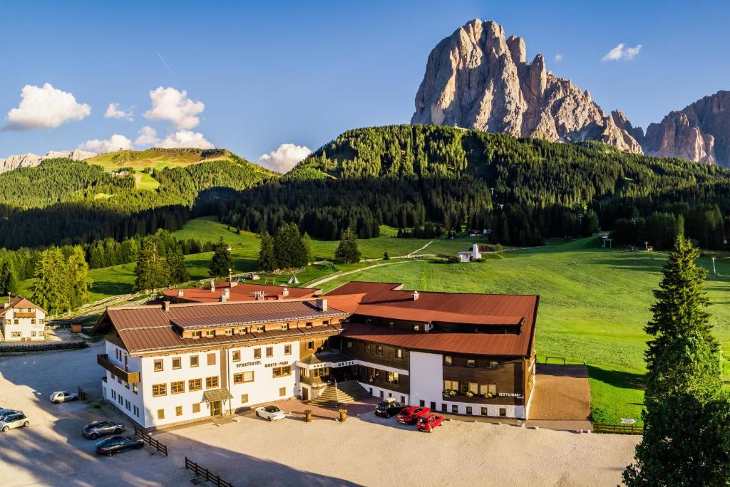 圣克里斯蒂娜Monte Pana Dolomites Hotel的享有酒店空中景色,以山脉为背景