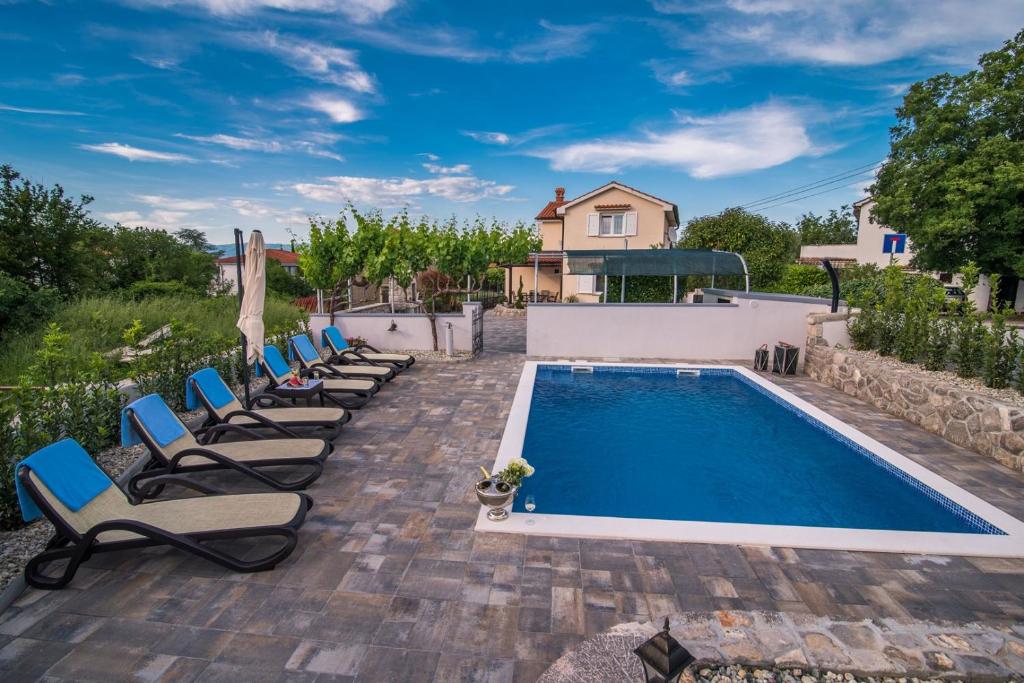 马林斯卡Villa Marina的房屋旁带躺椅的游泳池