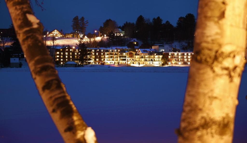普莱西德湖金箭湖畔度假酒店的享有夜间积雪的建筑景致