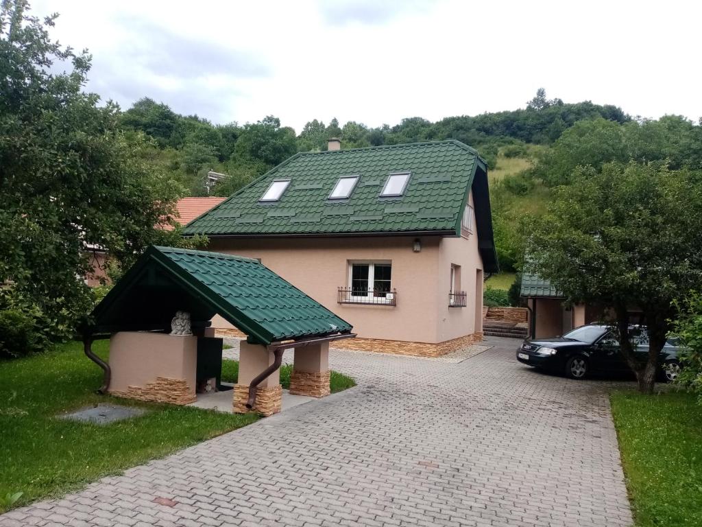 克雷姆尼察Apartmán Starý Mlyn的绿色屋顶和车道的房子