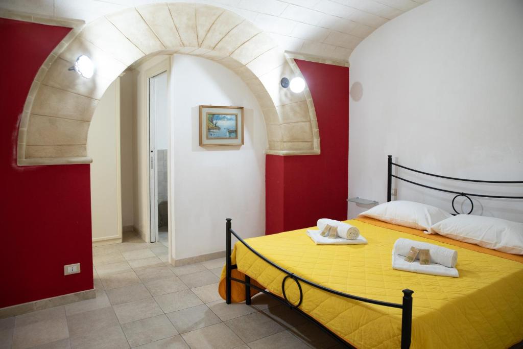 特拉帕尼伐戴拉250公寓的一间卧室设有黄色的床和红色的墙壁