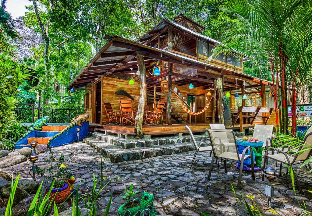 别霍港Congo Bongo EcoVillage Costa Rica的树林中的小屋,配有椅子和桌子