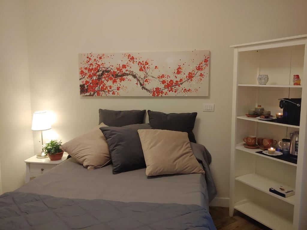 萨萨里TINY ROOM的卧室内的一张床铺,墙上有绘画作品