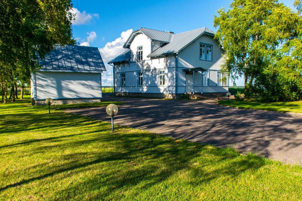库雷萨雷Villa Kuus Sõlme - Sea View Holiday Home的蓝色的房子,有大院子