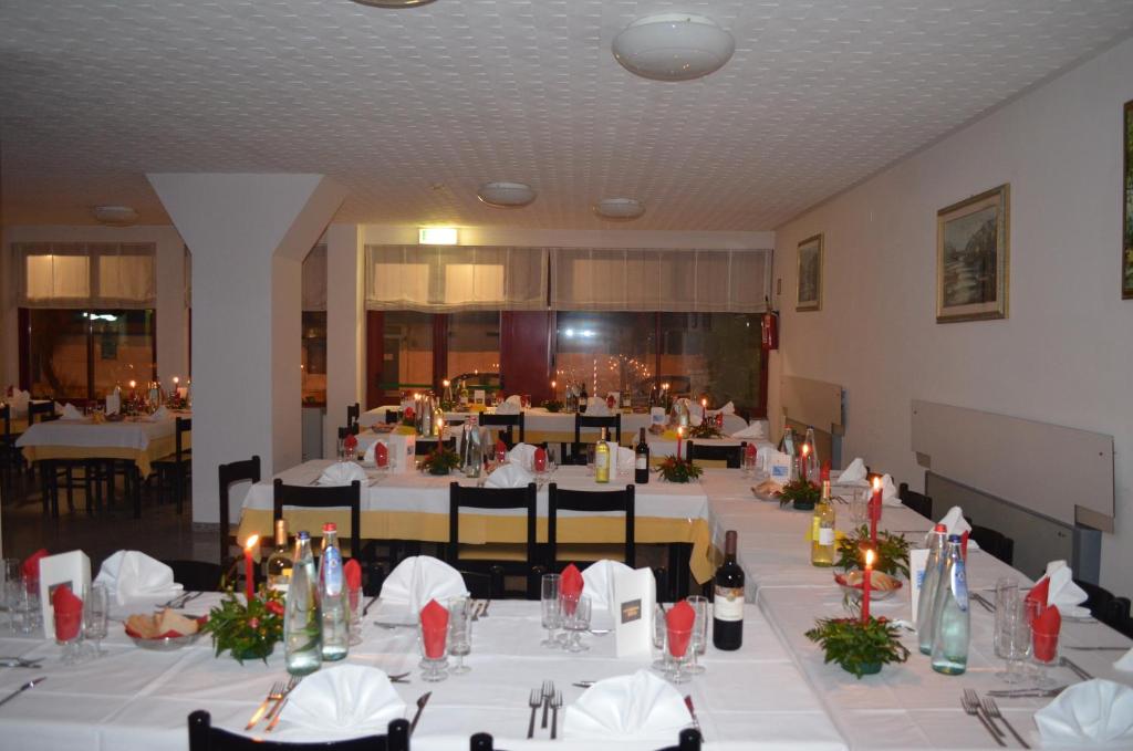 阿布鲁齐的罗塞托玫瑰草酒店 的一间大餐厅,配有桌椅和蜡烛