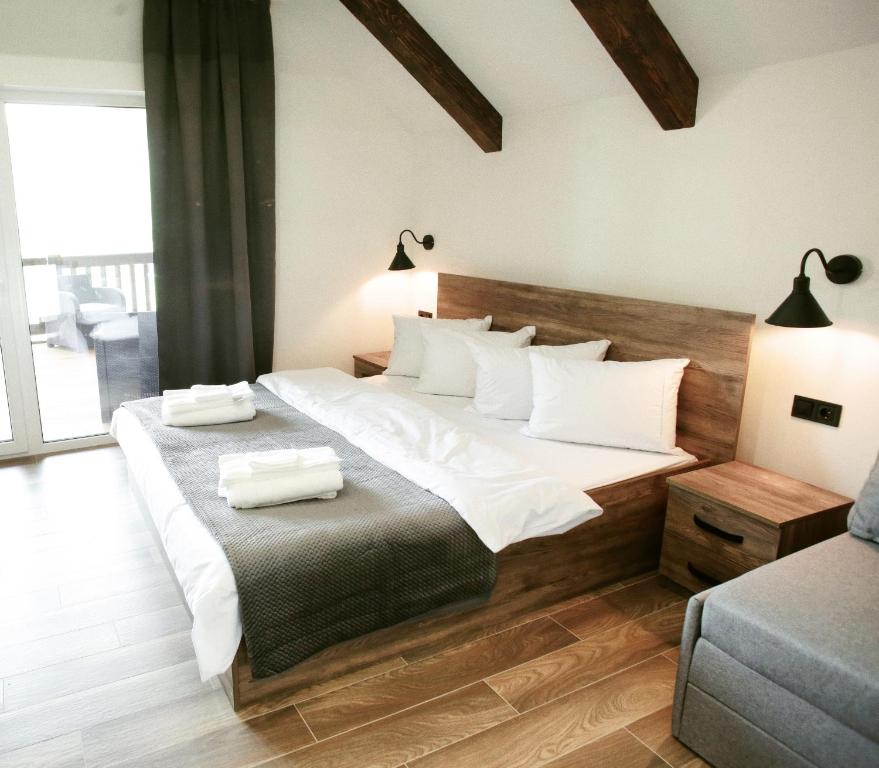 索洛钦Saliuk Lodge的卧室配有一张带白色床单和枕头的大床。