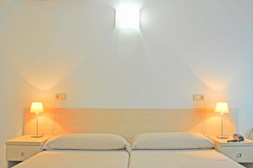 塔拉戈纳圣约迪大学旅舍的两张床位于带两盏灯的墙上。