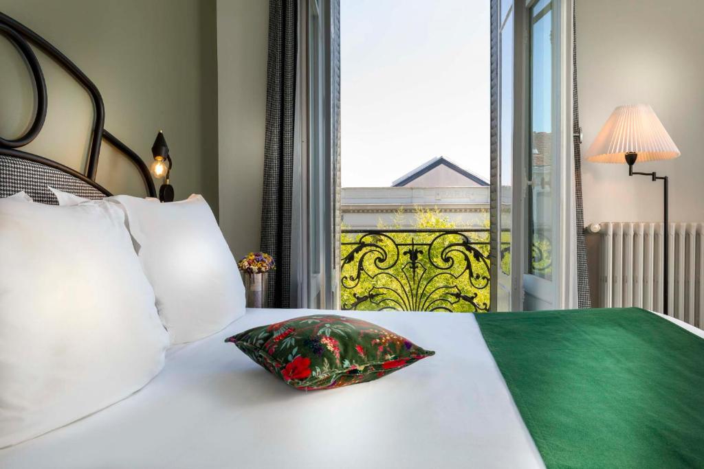 索恩河畔沙隆圣雷吉斯酒店的一张带枕头的床和窗户