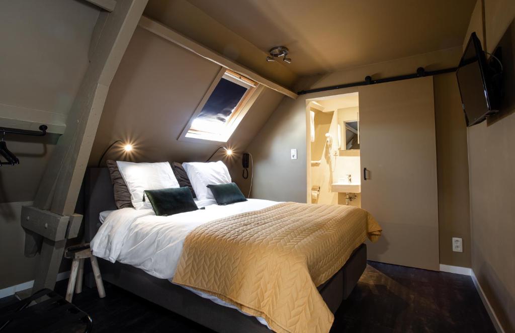 安特卫普Hotel1875的一间卧室设有一张床、一个窗口和一台电视