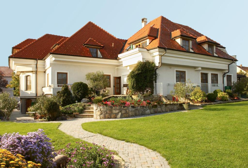 滨湖默尔比施Landhaus Luka的一座带草地庭院的大型白色房屋
