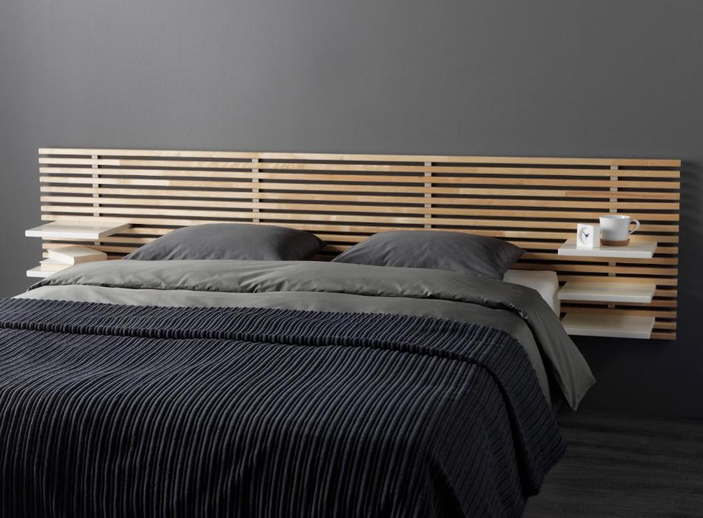 日内瓦拱廊饭店的一间卧室配有一张大床和木制床头板