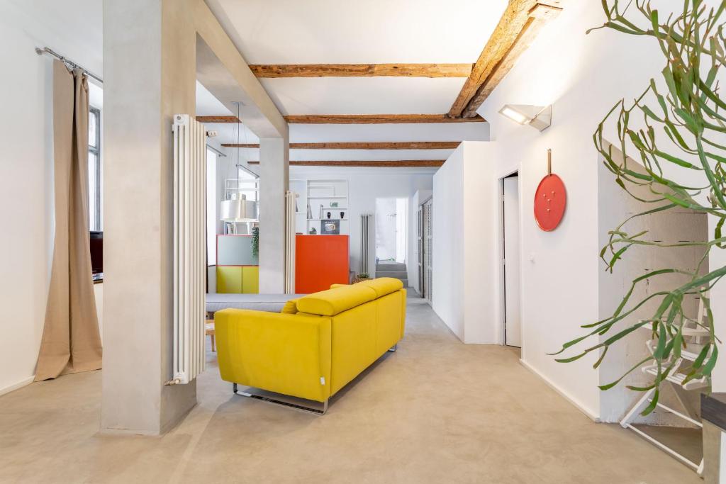 马赛Chic et moderne的白色墙壁的房间里一张黄色的沙发