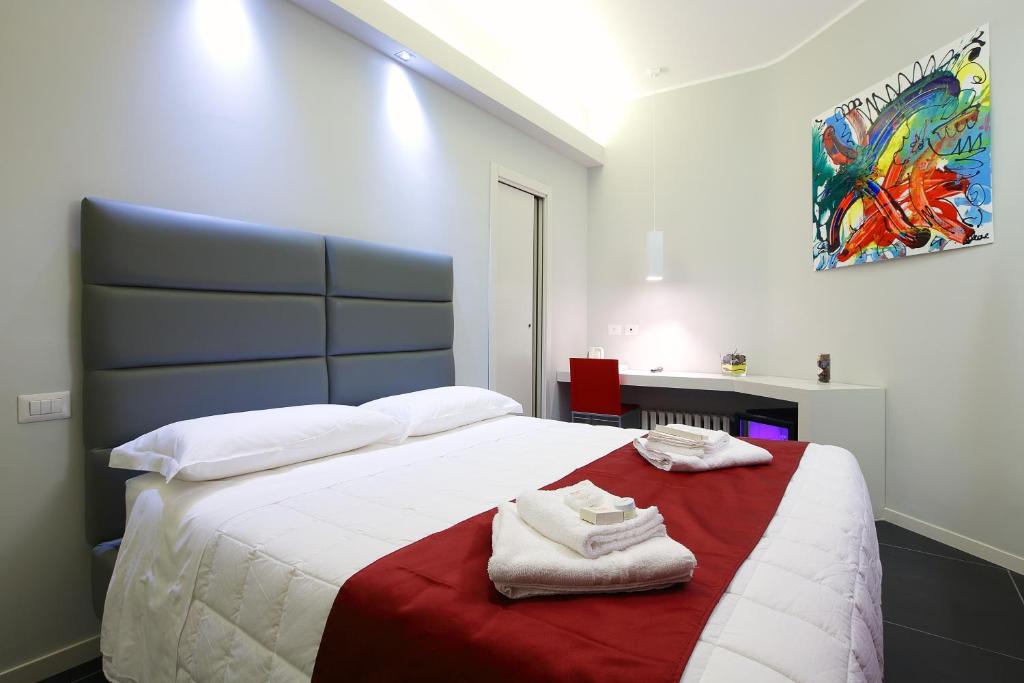 罗马近家漂亮套房旅馆的一间卧室配有一张大床和毛巾