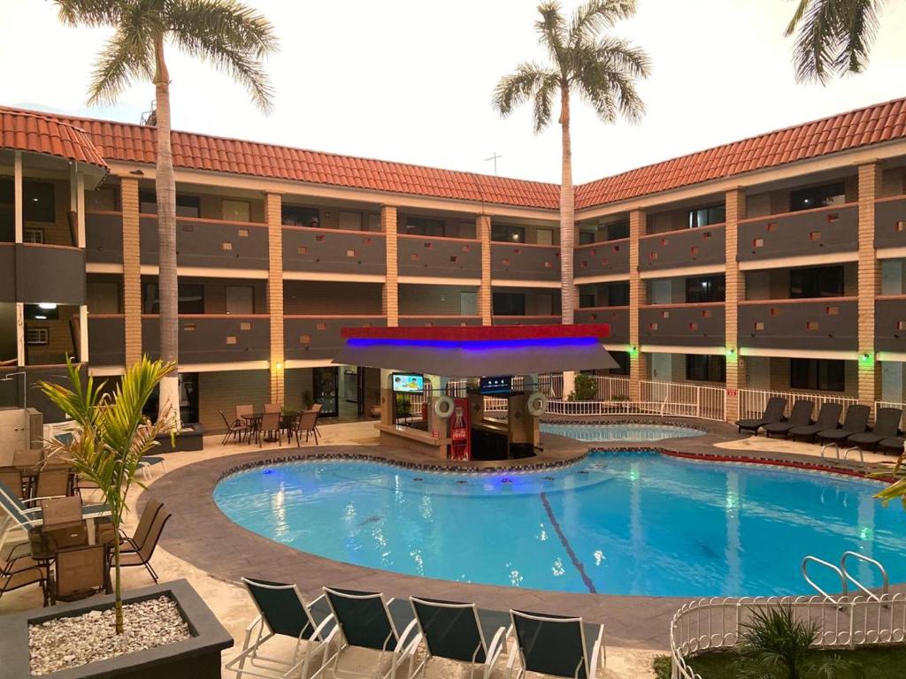 埃莫西约Hotel La Finca的棕榈树酒店前的游泳池