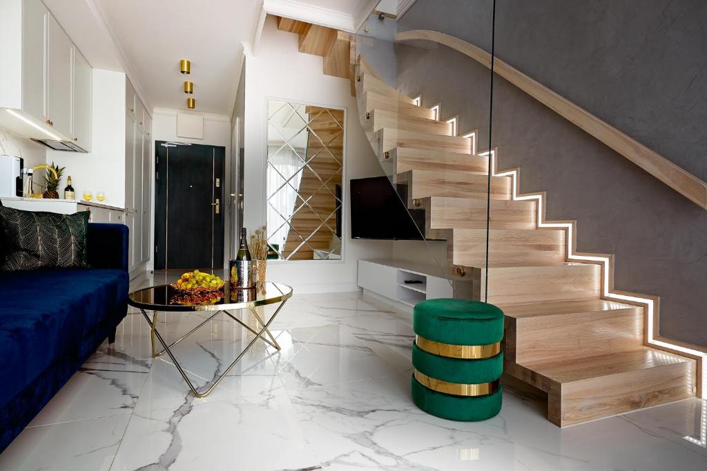 斯维诺乌伊希切Luxury Del Sol Apartments Świnoujście的客厅设有楼梯和蓝色沙发