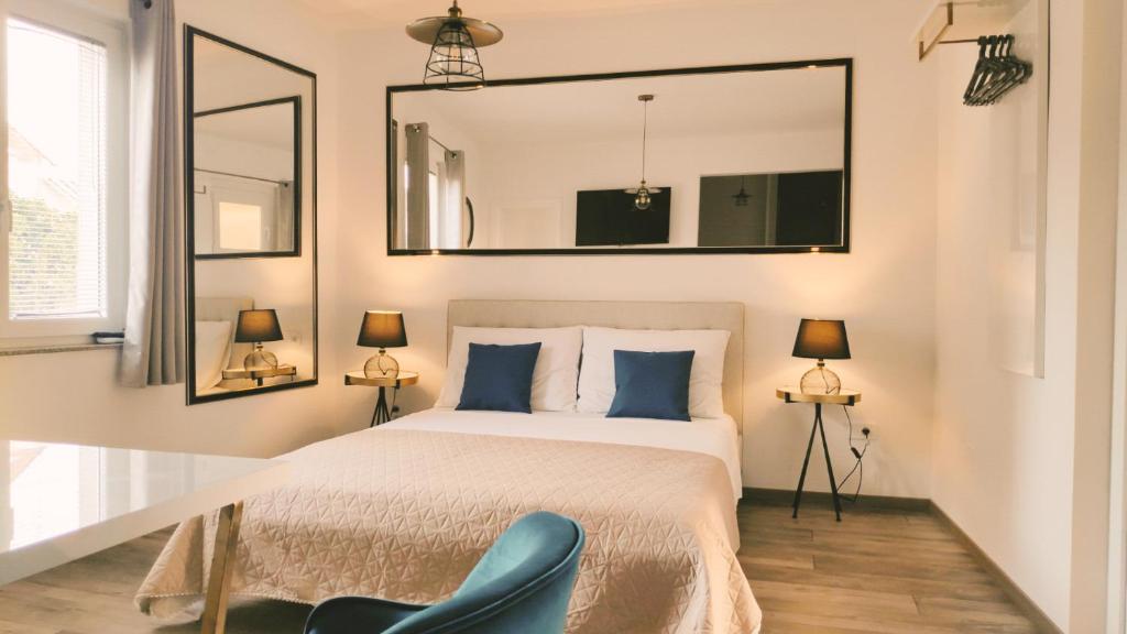 沃迪切Central Park Suites的一间卧室配有一张带镜子和蓝椅的床