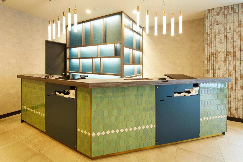 东京ICI HOTEL Tokyo Hatchobori的厨房设有蓝色和绿色的吧台