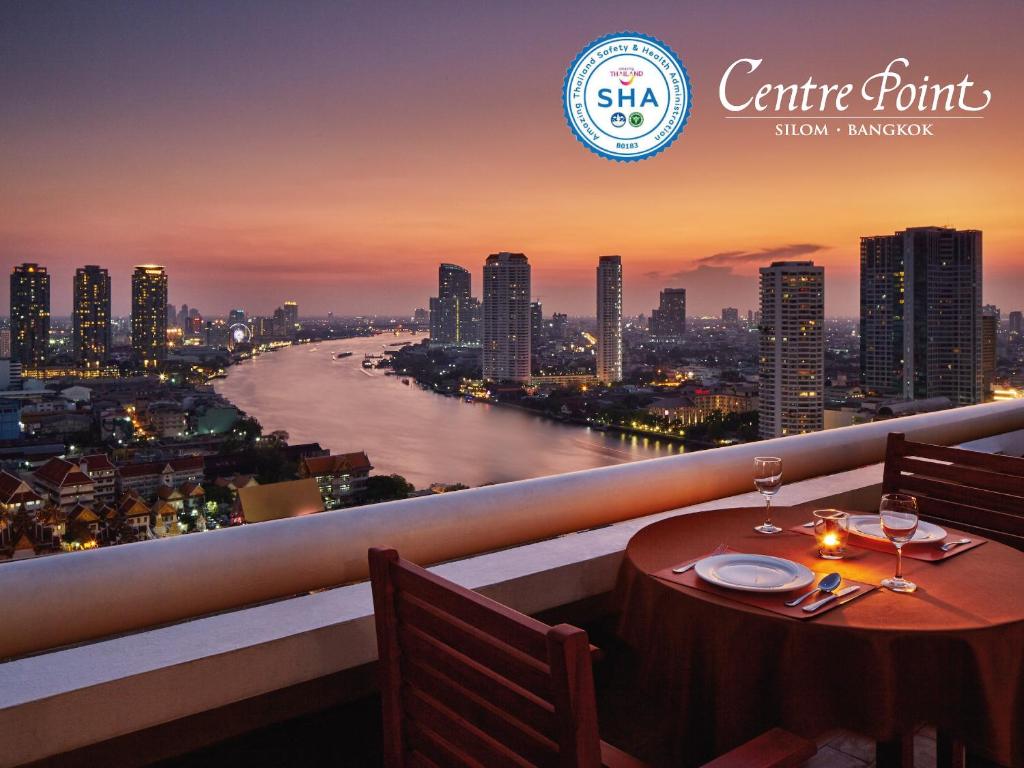 曼谷是隆中央酒店的河景阳台的桌子和酒杯