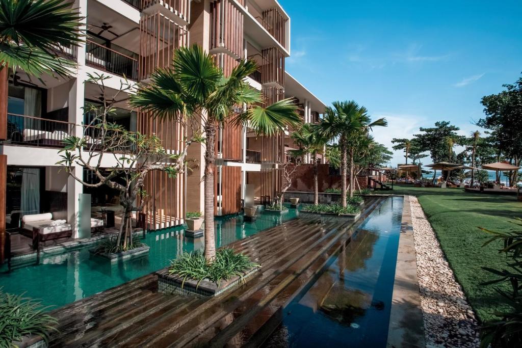 塞米亚克Grand Seminyak - Lifestyle Boutique Bali Resort的一座酒店庭院,在一座建筑前方种有棕榈树