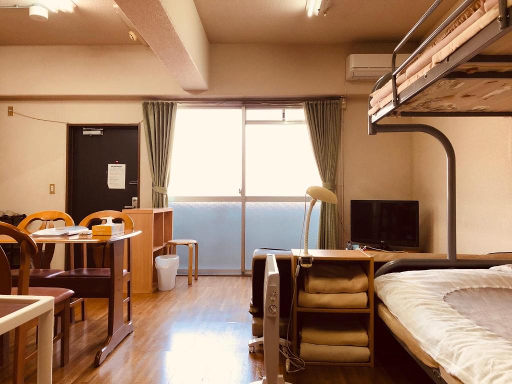 京都Nishijin IVY 5 persons room的一间卧室配有双层床、书桌和电脑