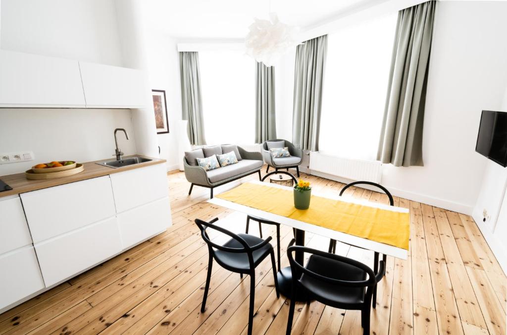 布鲁塞尔FLATS - Résidence D'ici D'ailleurs的厨房以及带桌椅的起居室。