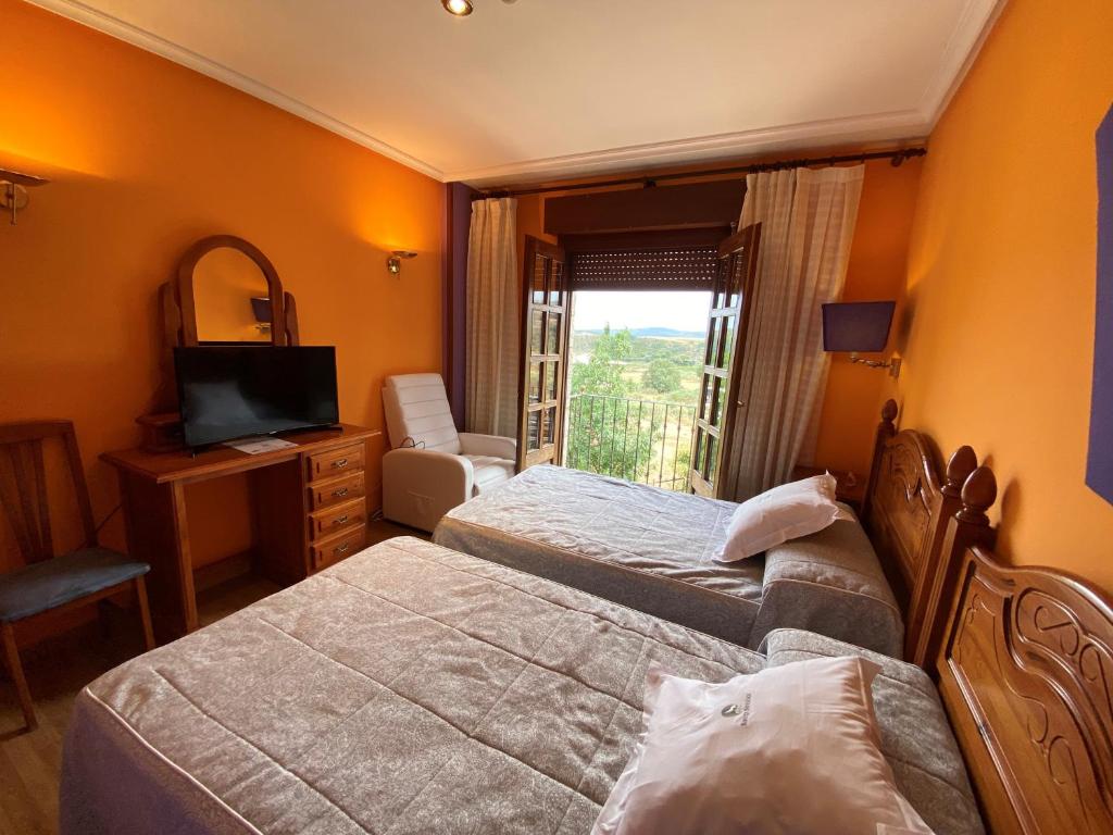 普韦布拉桑纳比亚提拉罗伯士酒店的酒店客房设有两张床和电视。
